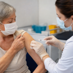 Pessoa idosa recebe vacina contra doenças pneumocócicas em unidade de saúde