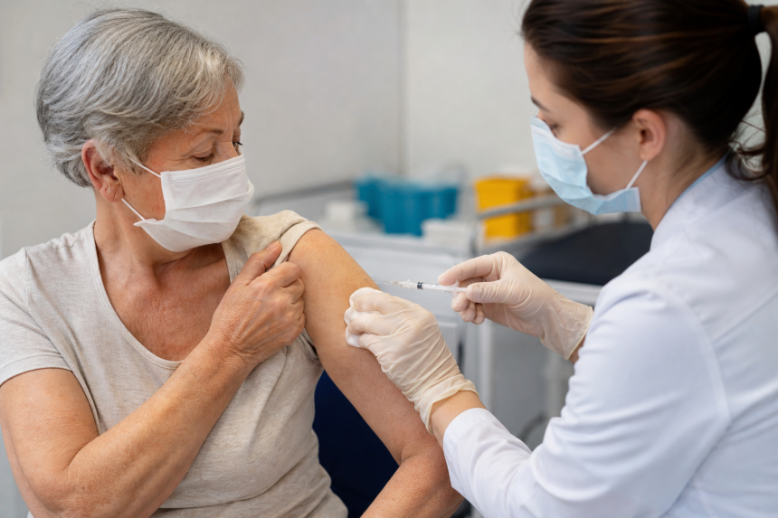 Pessoa idosa recebe vacina contra doenças pneumocócicas em unidade de saúde