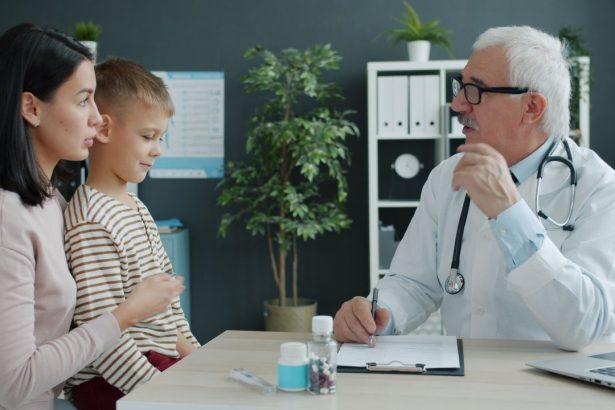 Profissional de saúde conversa com uma criança e sua mãe em uma clínica pediátrica.